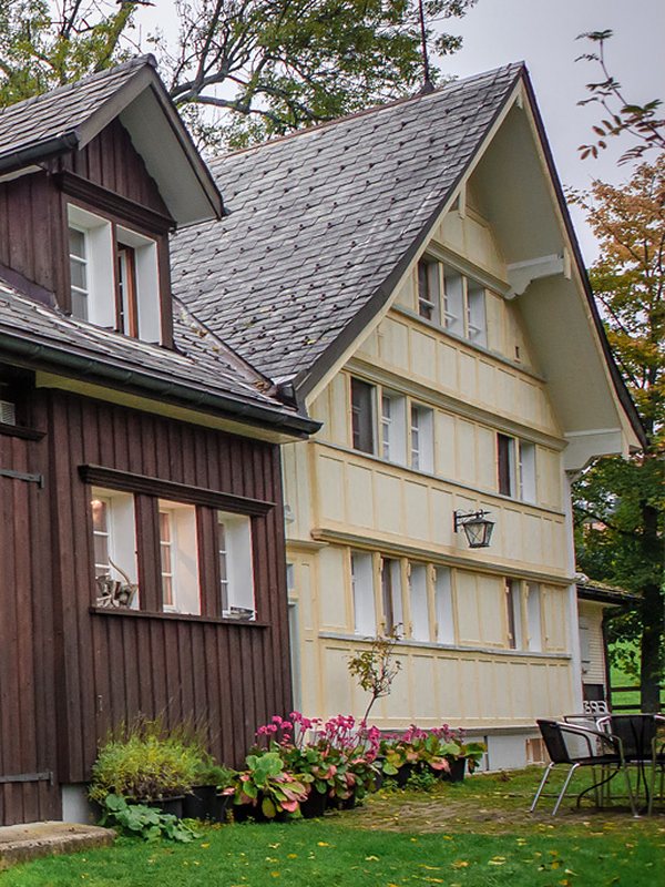 Appenzellerhaus Wissegg mit Giebelfassade, Blumen und Sitzplatz im Garten